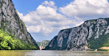 Ultima săptămână de vară are darul de a ne chema spre locuri spectaculoase, unde natura își arată puterea și frumusețea neîmblânzită. Un astfel de loc este Defileul Dunării, mai ales în porțiunea sa cea mai dramatică: Cazanele Dunării. Aici, fluviul se strânge între pereți de stâncă înalți de sute de metri și pare că „fierbe”, într-un spectacol care taie răsuflarea chiar și celui mai obișnuit privitor.
