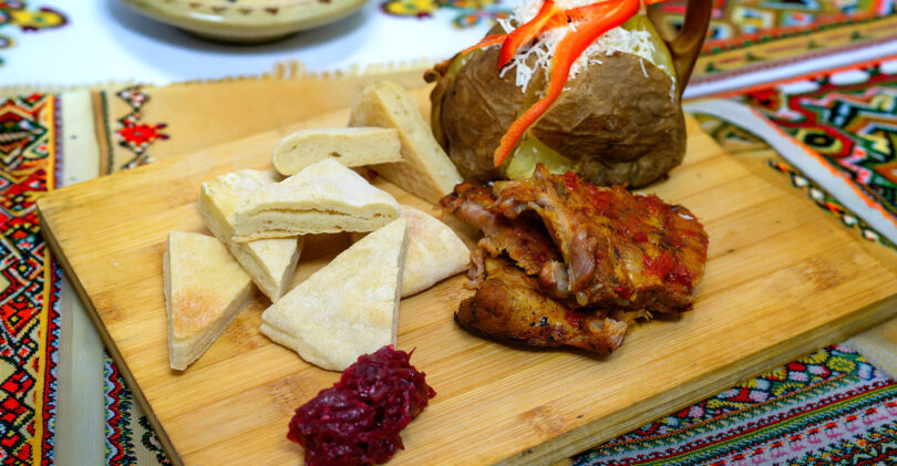 ROMÂNIA ÎN BUCATE: Coaste de porc caramelizate cu cartofi copți, brânză și dulceață de ardei iuți