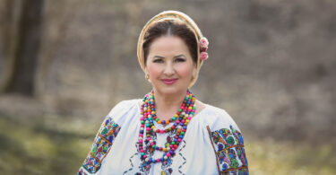 Cunoscută și iubită de public pentru energia și farmecul cântecului „Zi-i, Vasile, zi-i”, Margareta Clipa este una dintre vocile care au dus mai departe, cu autenticitate, spiritul Bucovinei. Cu o carieră construită într-o perioadă în care afirmarea se câștiga greu, prin scenă, concursuri și multă muncă, artista a rămas fidelă valorilor care au consacrat-o: respectul pentru tradiție, naturalețea și bucuria de a cânta pentru oameni. Dincolo de succesul pieselor sale, povestea Margaretei Clipa este despre rădăcini, disciplină și un drum parcurs cu răbdare, pas cu pas. În acest interviu, descoperim omul din spatele cântecului și felul în care muzica i-a devenit destin.